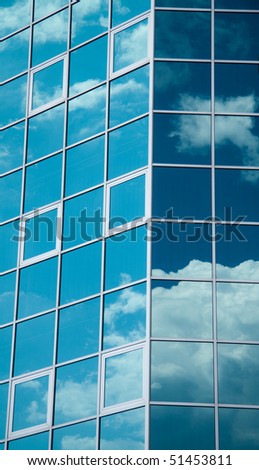 modern architecture building made of glass reflecting the clouds