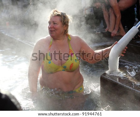 KHARKIV, UA - JANUARY 19: Unidentified Kharkov woman swimming in ice cold water during Epiphany (Holy Baptism) in the Orthodox tradition, January 19, 2011 in Kharkov, Ukraine