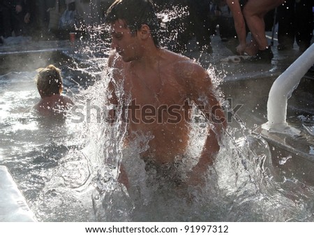 KHARKIV, UA - JANUARY 19: Unidentified Kharkov man swimming in ice cold water during Epiphany (Holy Baptism) in the Orthodox tradition, January 19, 2011 in Kharkov, Ukraine