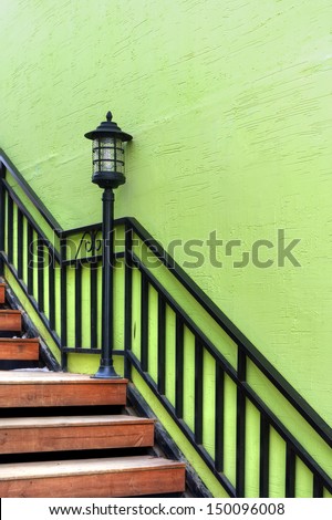 Retro lamp on stairs with green wall