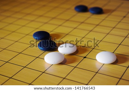 Picture taken during a game of go. Go is an ancient traditional Asian board game. Shallow depth of field.