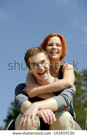 Portrait of a young beautiful happy couple outside man carrying woman smiling