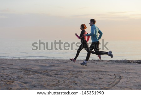 Young Man And Woman Running Along The Waterfront