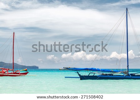 Blue and red sailing boat on deep blue see. Sunny day with blue sky and white clouds. Philippines Boracay
