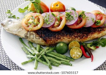 A Grilled milk fish with vegetables garnishing