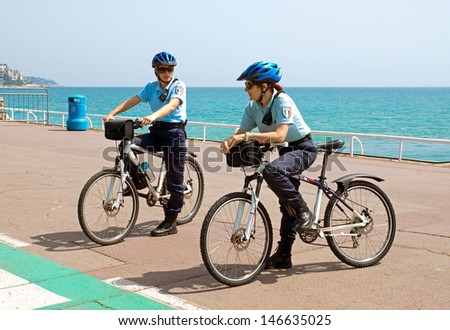 NICE, FRANCE - MAY 2: Women police officers on bicycles. Cote d\'Azur, the Promenade des Anglais on May 2, 2013 in Nice, France. Bikes are very popular among municipal employees.