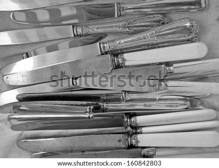 Background of heap old fashioned silver knives.