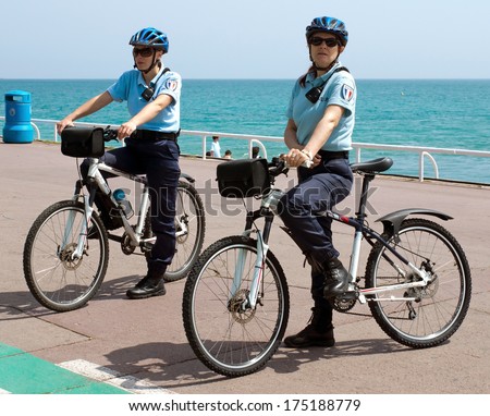 NICE, FRANCE - MAY 2: Women police officers on bicycles. Cote d'Azur, the Promenade des Anglais on May 2, 2013 in Nice, France. Bikes are very popular among municipal employees.