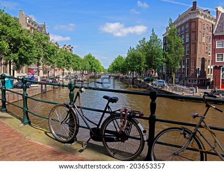 AMSTERDAM, NETHERLANDS - MAY 30: Bicycles on a bridge over the canal on May 30, 2014 in Amsterdam, Netherlands. Bikes are very popular in the Netherlands, the average Dane travels 900 km per year.