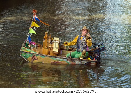 AMSTERDAM, NETHERLANDS - MAY 30: Unknown musician in a boat on May 30, 2014 in Amsterdam, Netherlands. Everyday buskers perform on the streets and canals in Amsterdam.