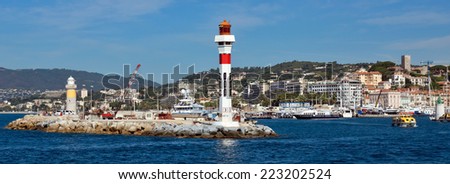 CANNES, FRANCE - JUNE 5, 2014: Lighthouse tower at port entrance in city of Cannes, France. Port de Cannes was started in 1745.