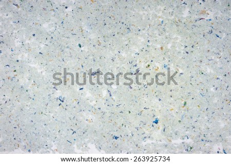 Handmade recycled paper background texture with rough patches.