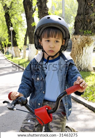 Little boy on a bike in a helmet.