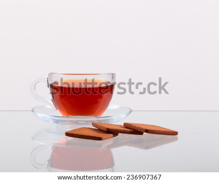 Cup of tasty hot tea, on white background, with christmas toys and cookies