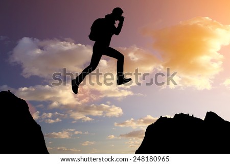 Silhouette of running man against the colorful sky. Silhouette of running man on sunset fiery background