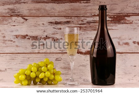 glass of wine, a bottle of wine and grapes on board