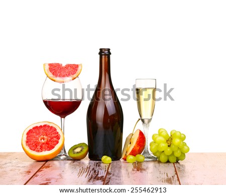 glass of red wine, a bottle of wine and grapefruit on board isolated on white background
