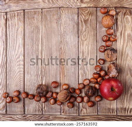 Autumn harvest. Apple and nuts on  on dark recycled wood background, with copy space.. Top view