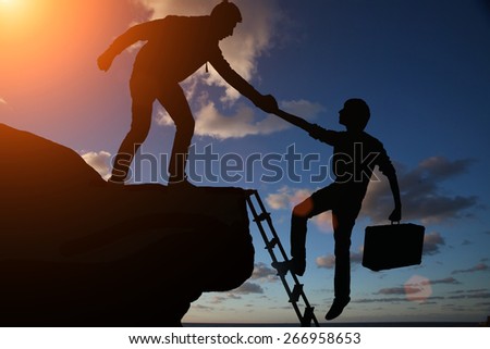 Teamwork of two men helping each other on top of mountain a career climbing team, concept of career ladder and teamwork