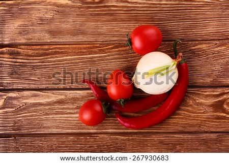 Fresh red tomato ,chilli,and onion in table wooden background (seen from above)