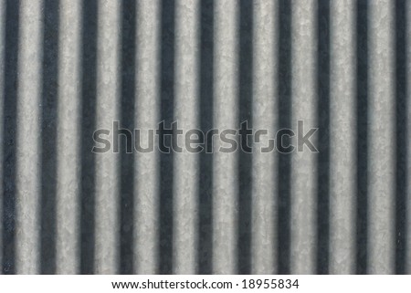 Antique weathered galvanized metal from the side of an old elevator form a pattern of stripes.