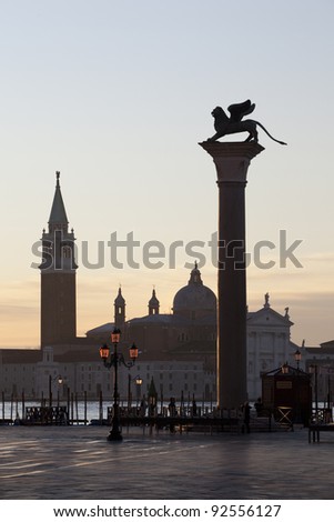 St. Mark\'s column on Piazza San Marco (Piazzetta di San Marco) in Venice with the Santa Maria della Salute church in the background at dawn