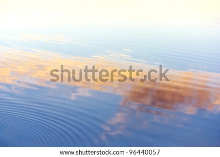 Waves on the water surface. Blue, orange, yellow tints