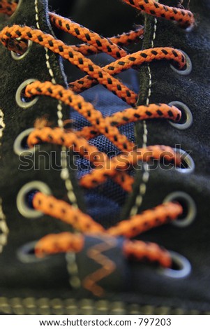 close up of black suede shoe with orange laces