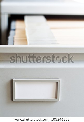 Opened drawer of a file cabinet showing various files.