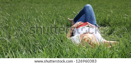 Attractive young woman taking a nap outside on a sunny day.