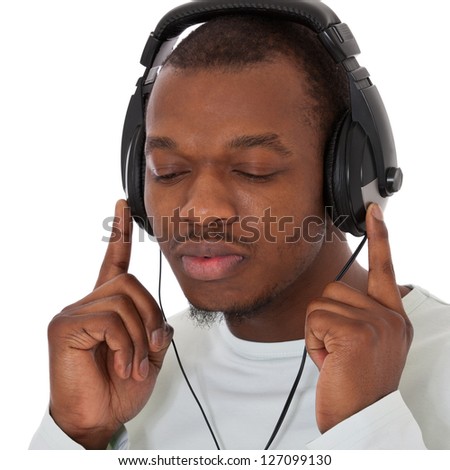 Attractive black guy listens to music with headphones. All on white background.