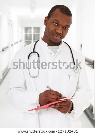 Black doctor writing clinical record.