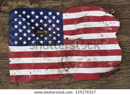 Old ragged flag of the United States of America. All on wooden background.