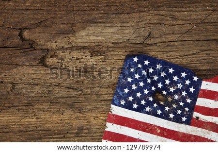 Old ragged flag of the United States of America. All on wooden background.