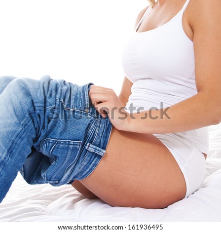 Attractive female person unfits her pants. All on white background.