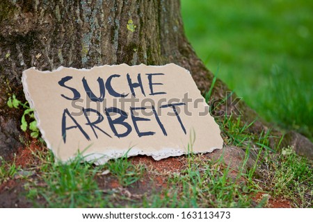 Cardboard sign showing the german term Suche Arbeit. English translation: looking for a job