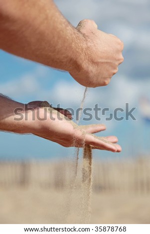 A person holding dry sand in his hands.