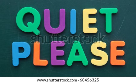The term quiet please in colorful letters on a blackboard.