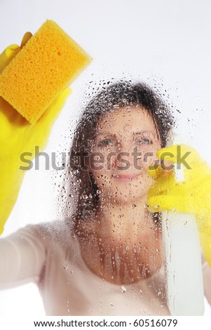 Attractive young woman cleaning windows. All isolated on white background.