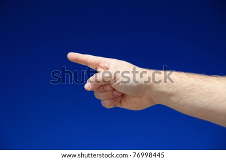 A person pointing with finger in front of bright blue sky