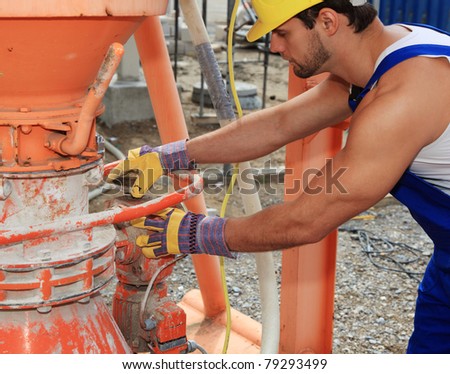 Construction worker at cement mixer.