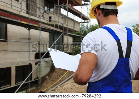 Manual worker on construction site during building inspection.