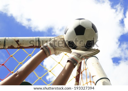 Soccer goalkeeper\'s hands reaching for the ball