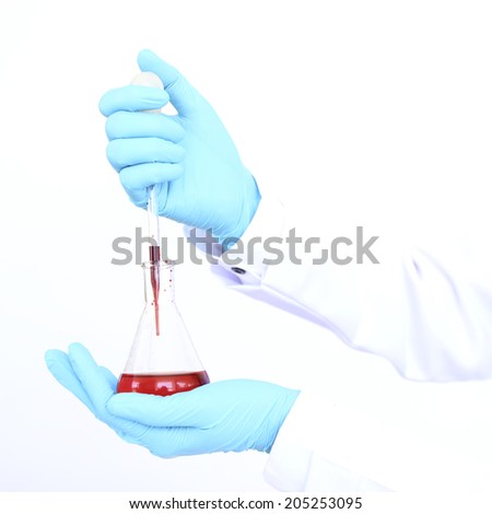 chemist holding tubing with liquid during chemical experiment