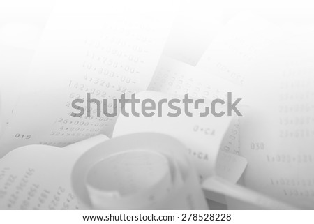 Paper cash register receipts in a lose pile close up with soft focus