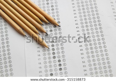 Standardized test form with answers filled in and a pencil, focus on answer sheet