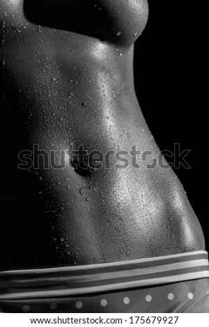 A monochrome image of a hot woman's wet body like after a workout.