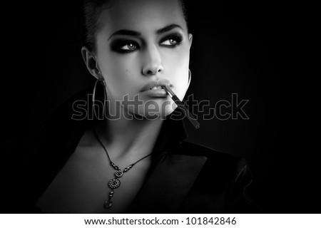 black and white fashion portrait of a beautiful young woman with cigarette