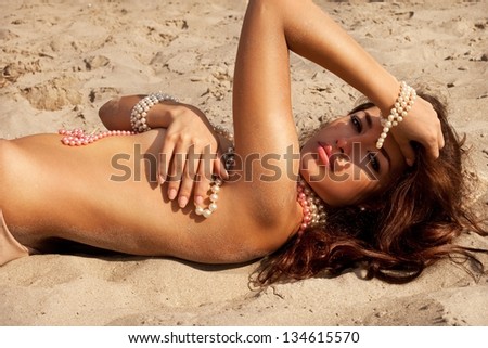 beautiful tanned woman posing in the sand, summer portrait