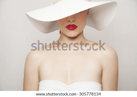 woman beauty portrait with red lips and summer white hat, studio